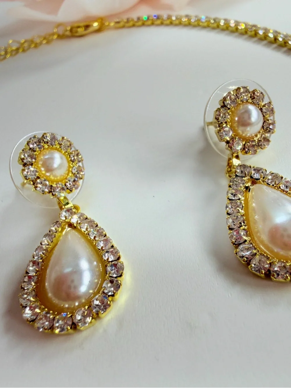 Elegant gold-tone necklace with earrings featuring a white teardrop pearl pendan